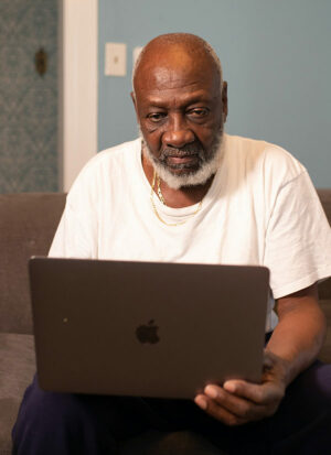 Older black man using a computer.