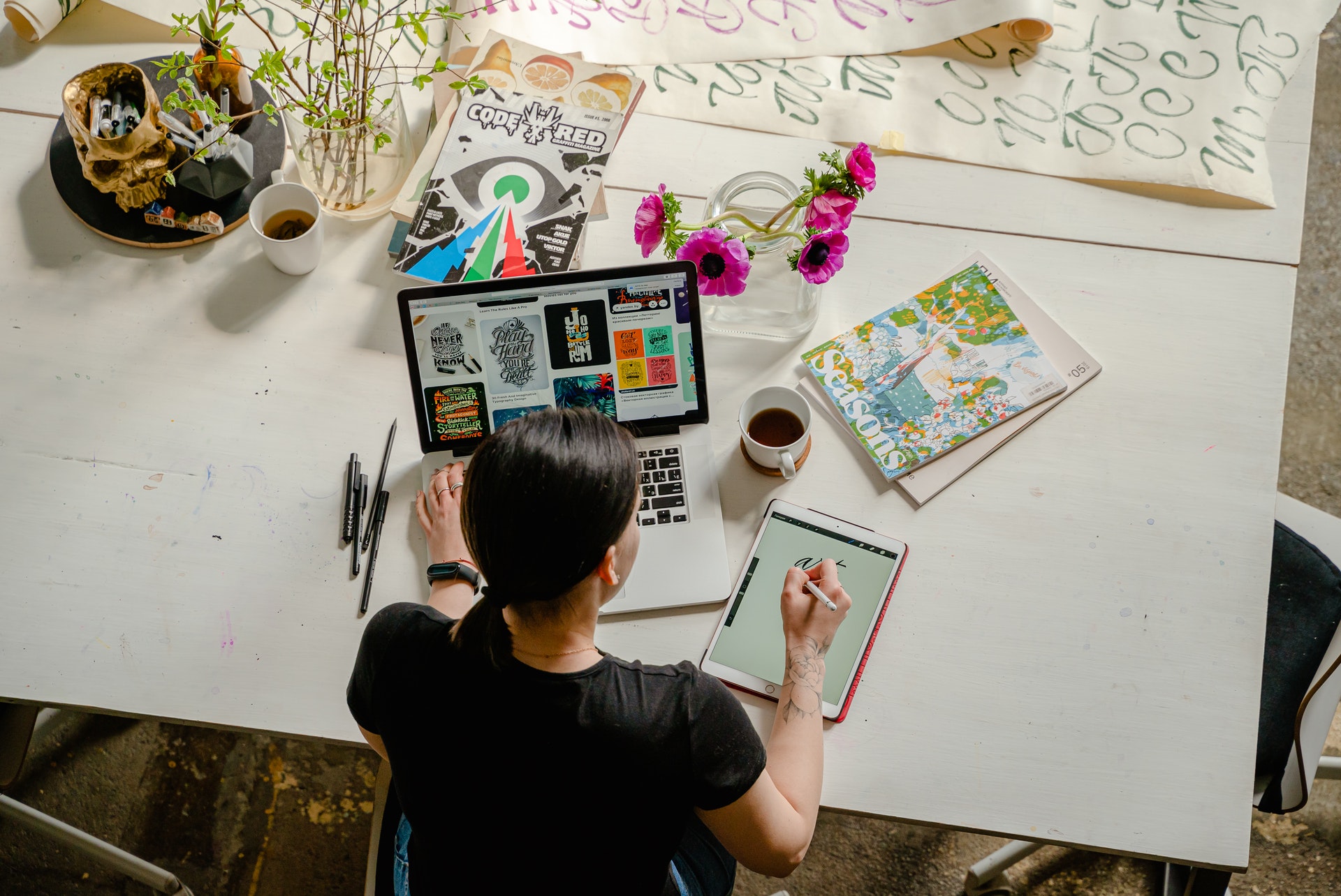 white woman sitting at a desk drawing