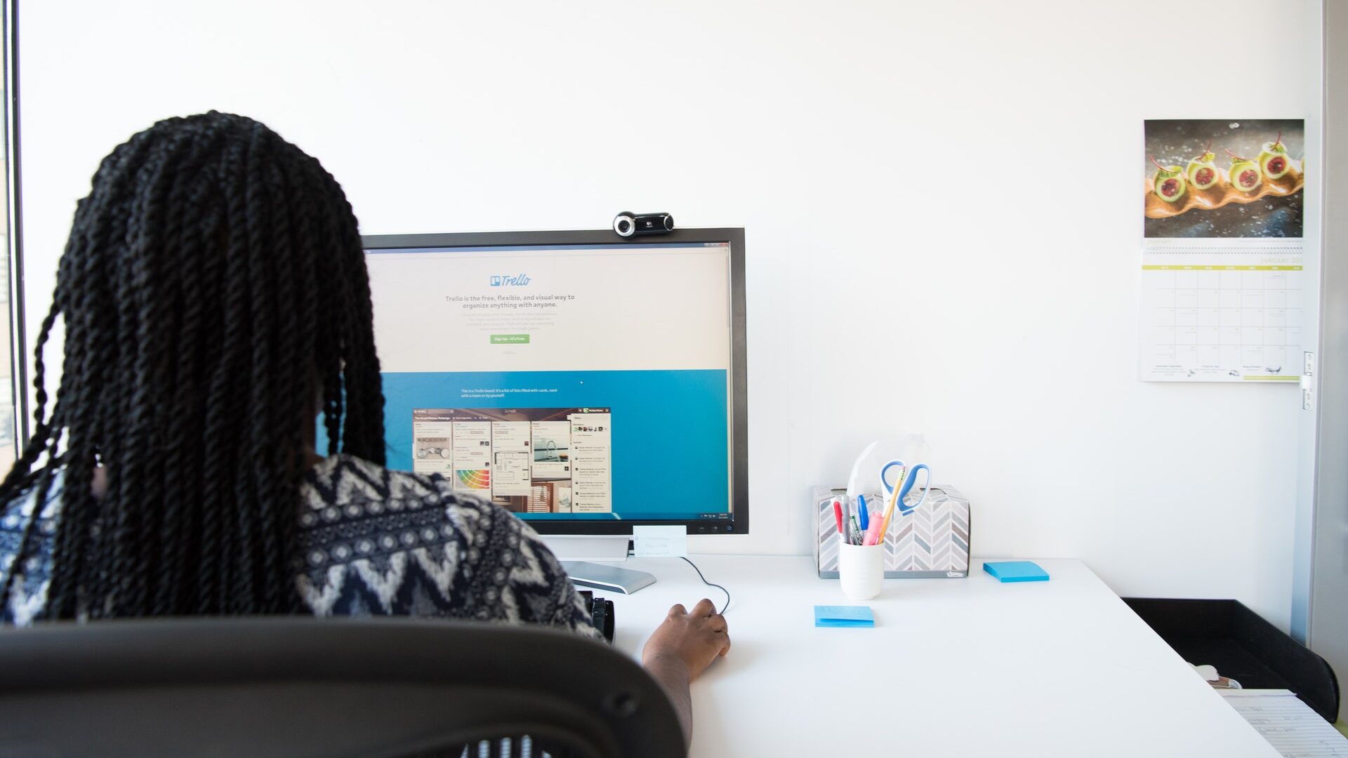 black woman sitting at a desk working on a computer