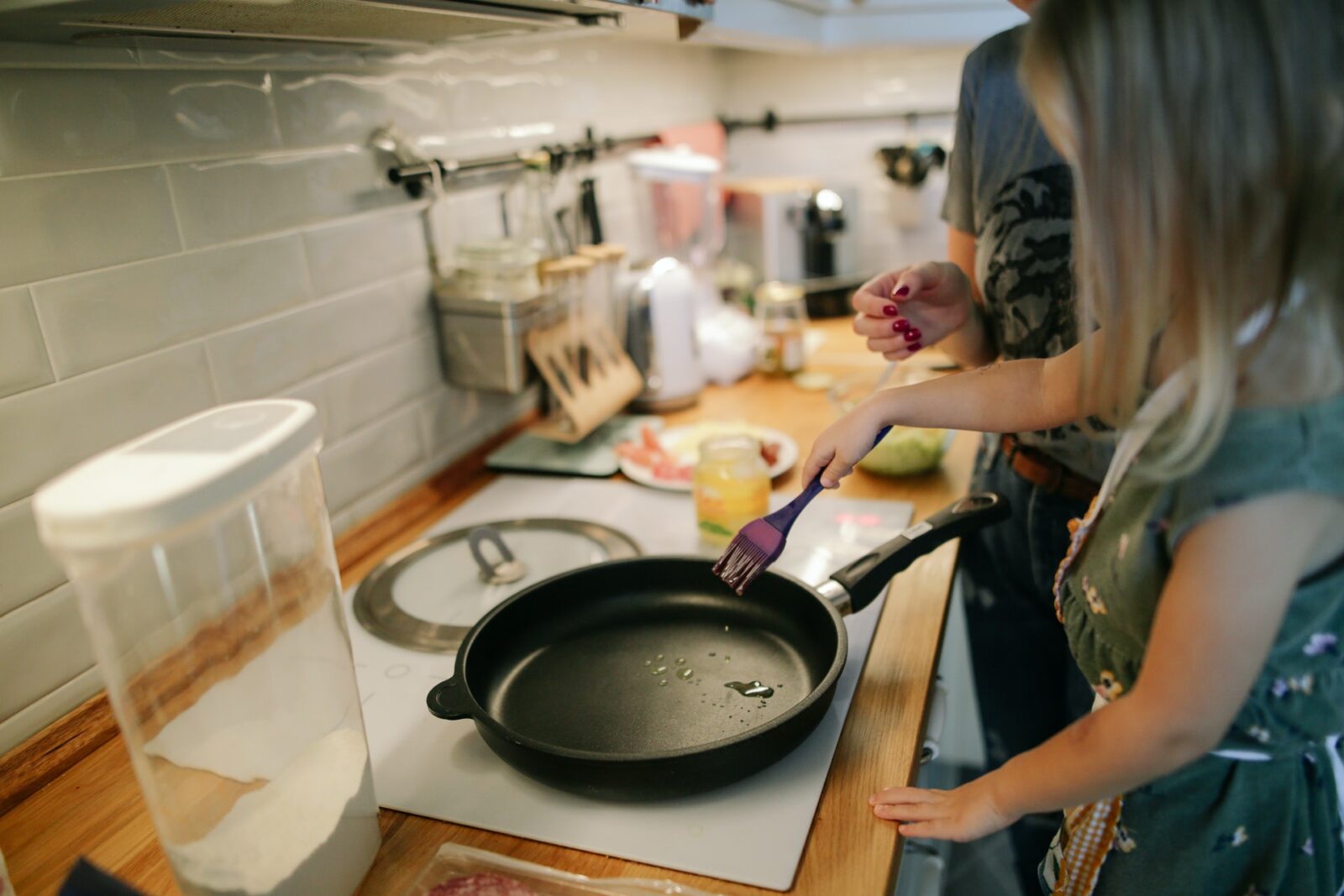 a white girl cooking in a kitchen with a skillet