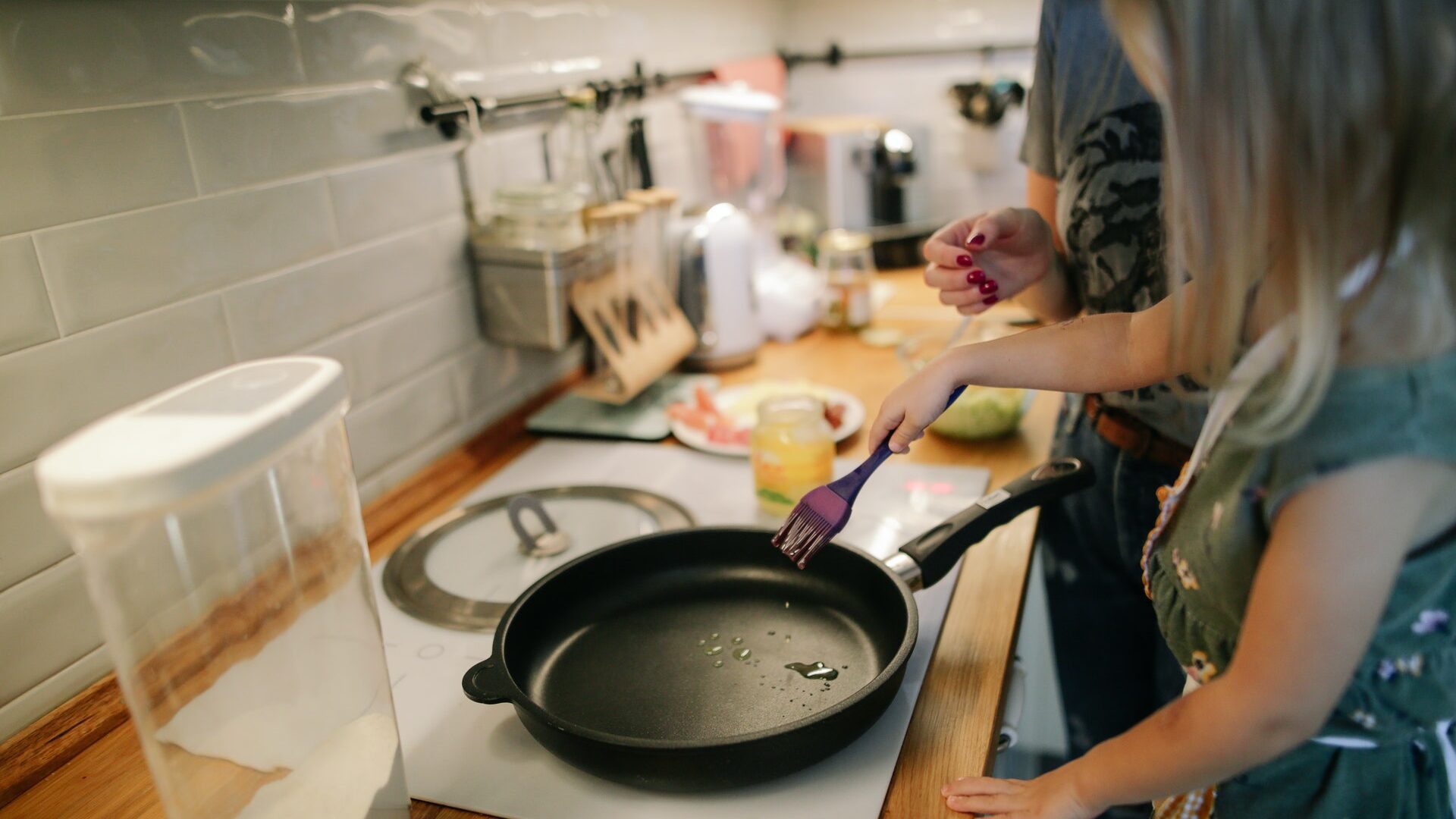 a white girl cooking in a kitchen with a skillet