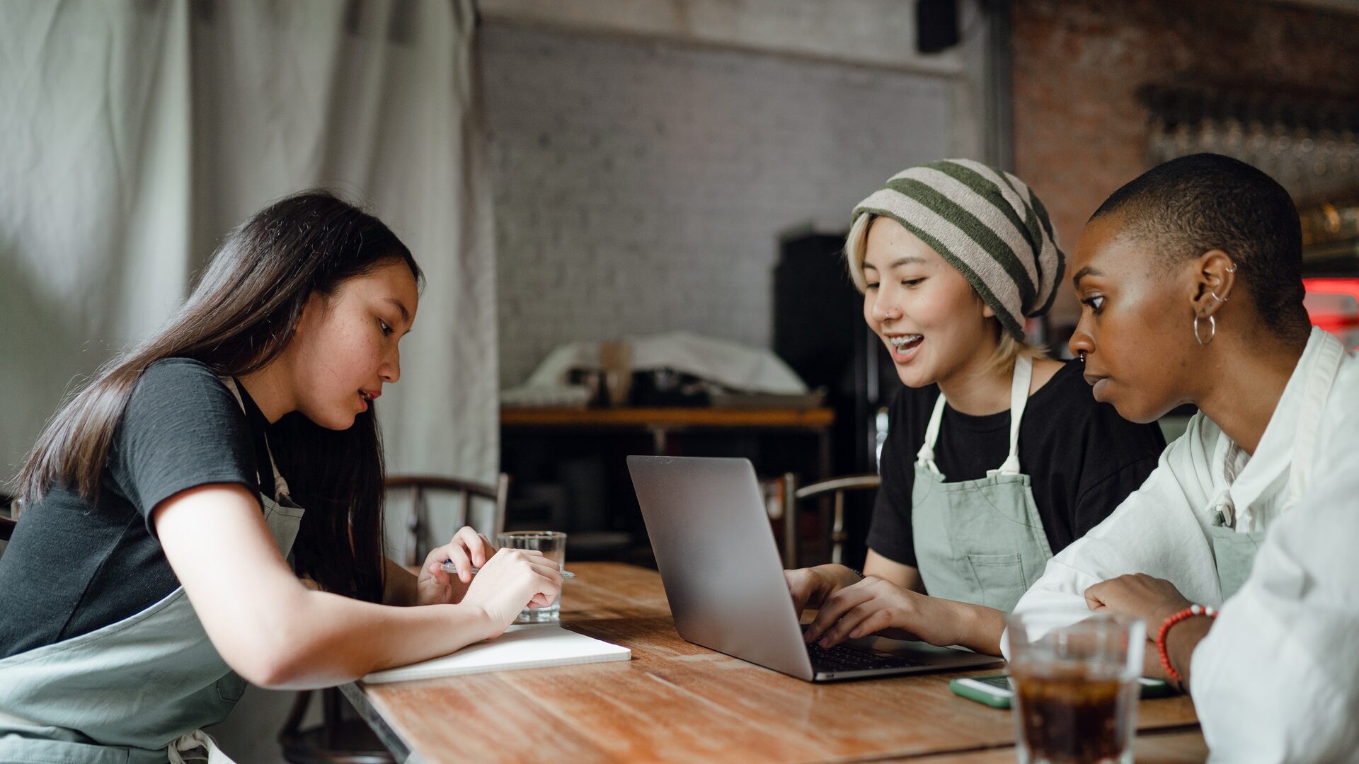 asian woman interviewing a black woman who is a chef and an asian woman in a restaurant