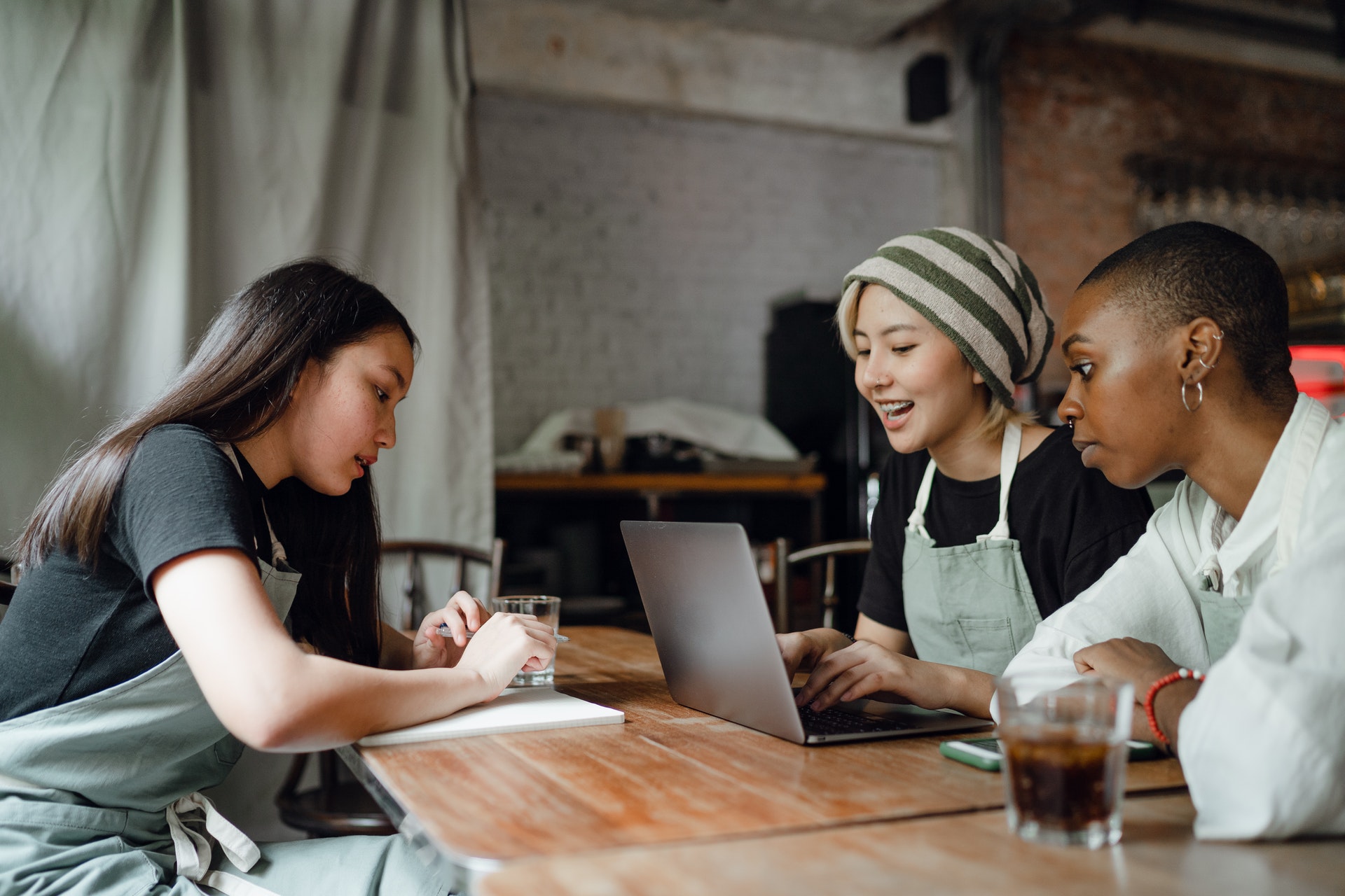 asian woman interviewing a black woman who is a chef and an asian woman in a restaurant