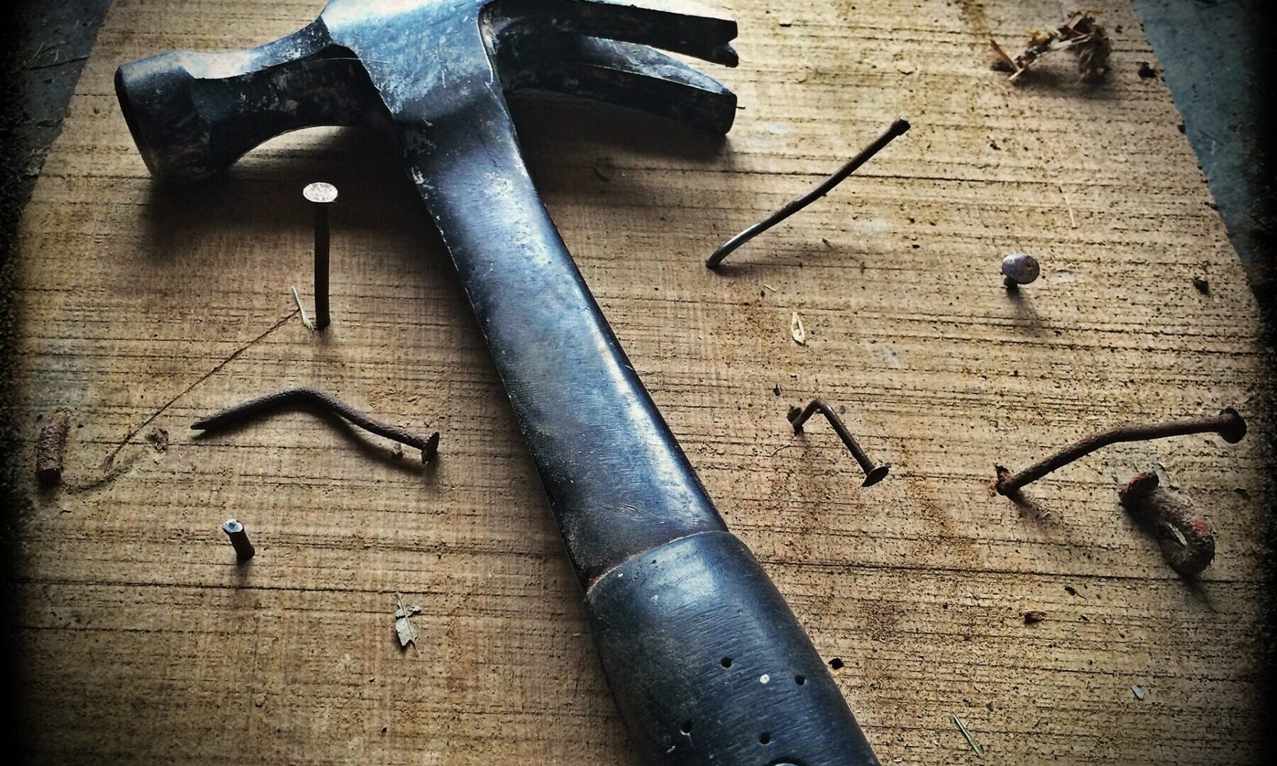 a hammer sitting on a table with nails