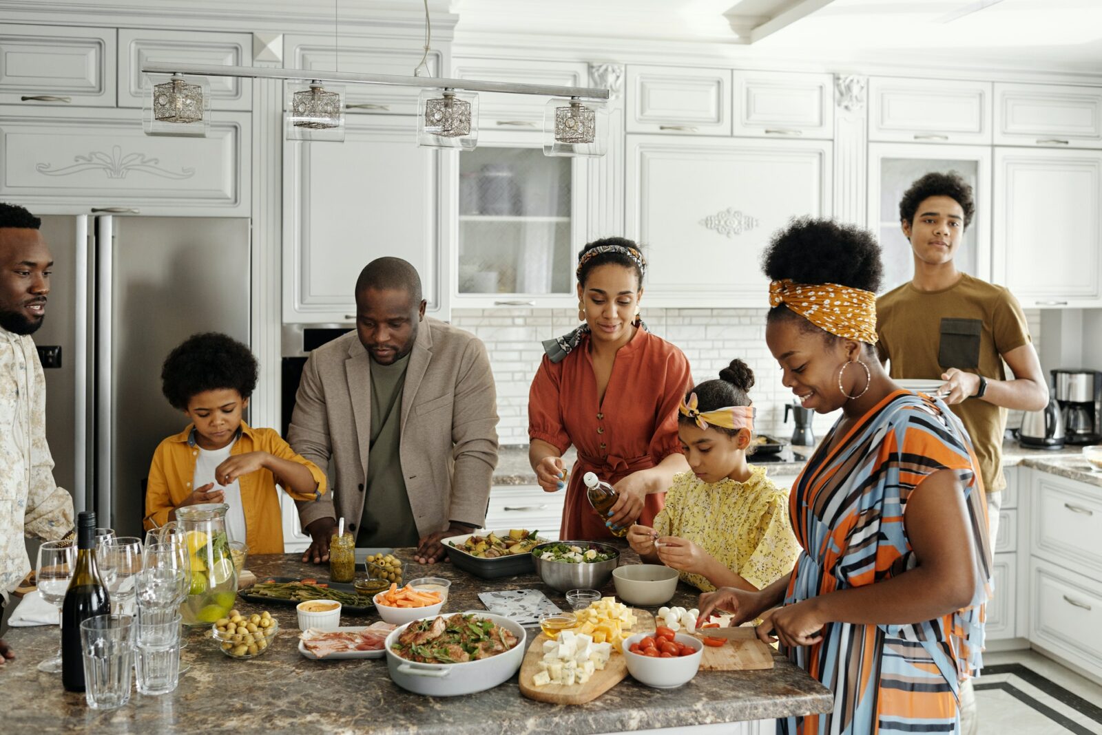 a family of mixed races standing at a kitchen table