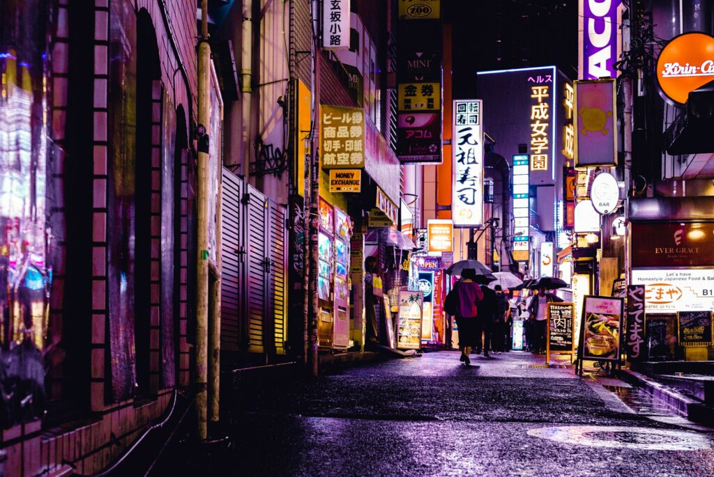 a wet city street in japan with glowing lights and wet streets - bright neon glows