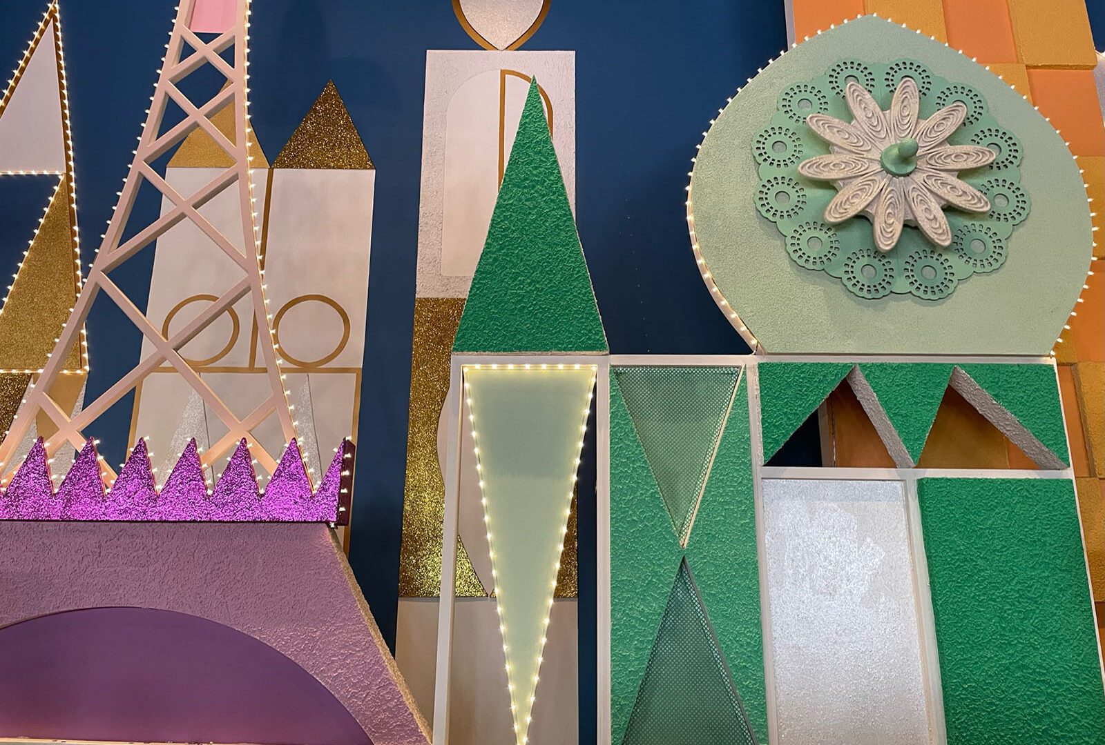 the walls inside It's a Small World, featuring glitter, the eifel tower, and other world monuments