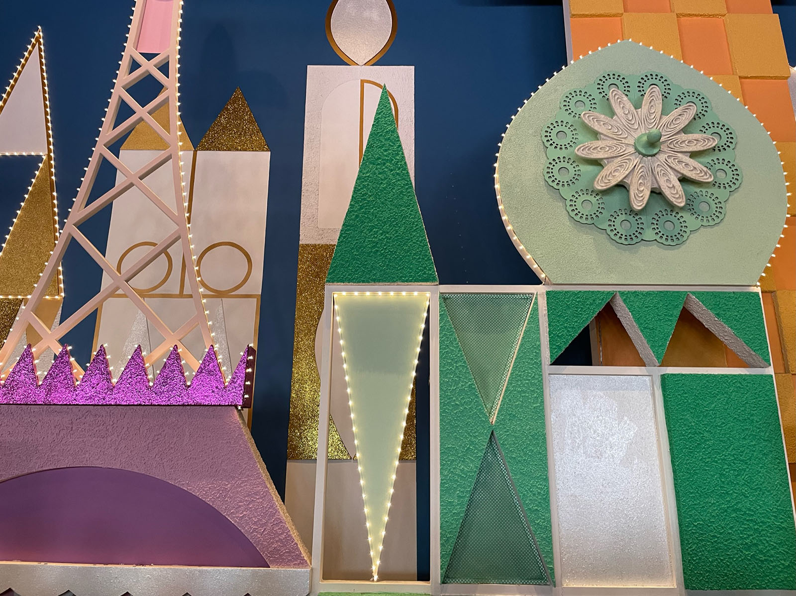 the walls inside It's a Small World, featuring glitter, the eifel tower, and other world monuments