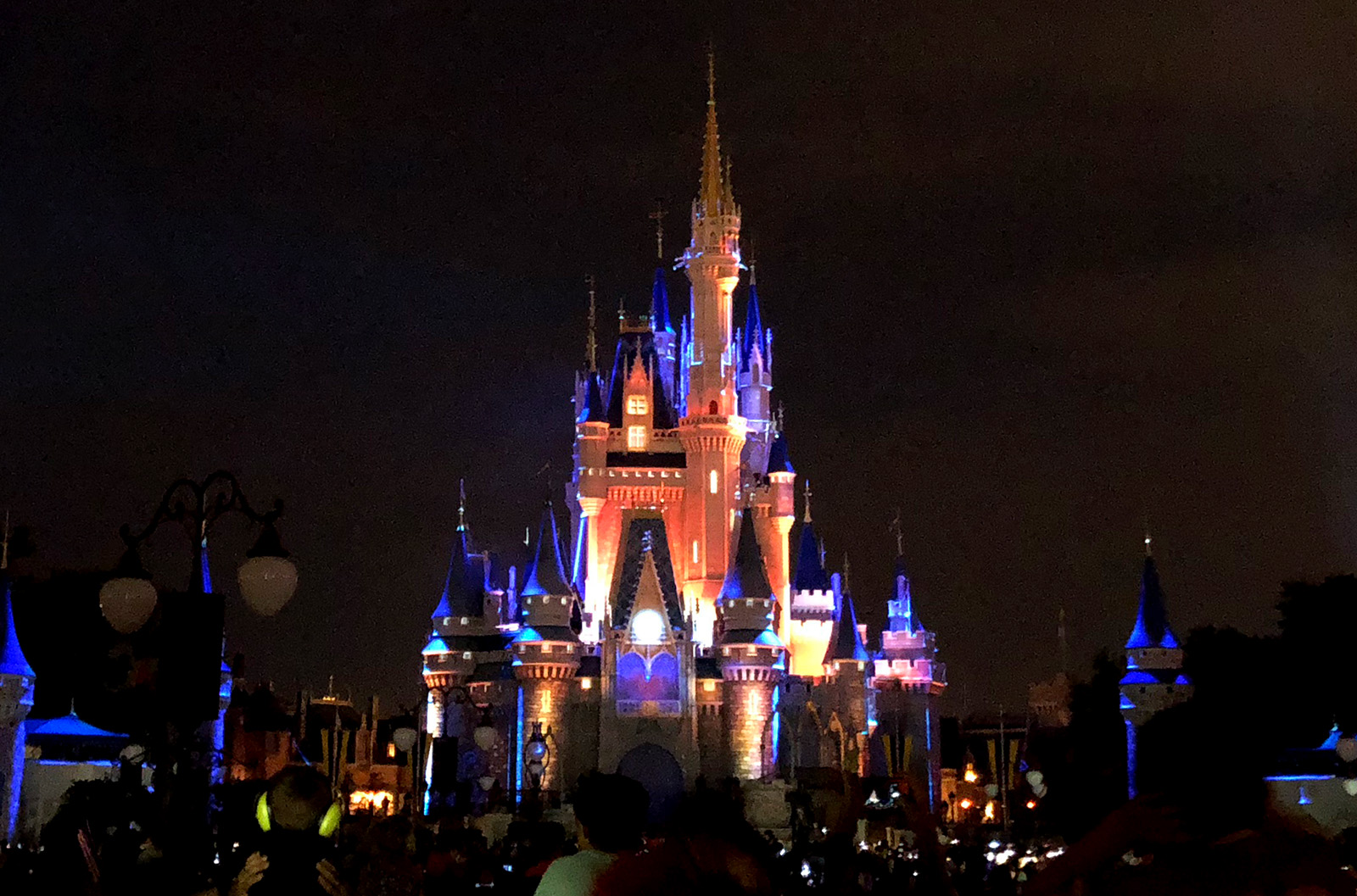 cinderella castle at disney world at night lit dramatically before a fireworks show