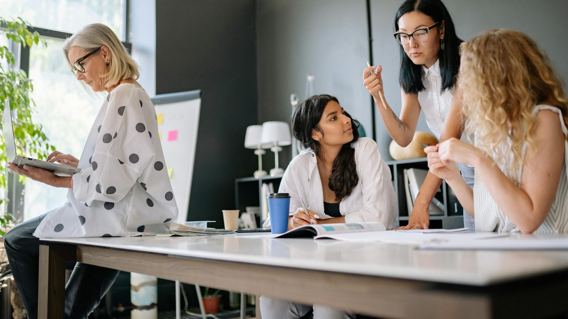 four women in an interior design practice discussing design work.