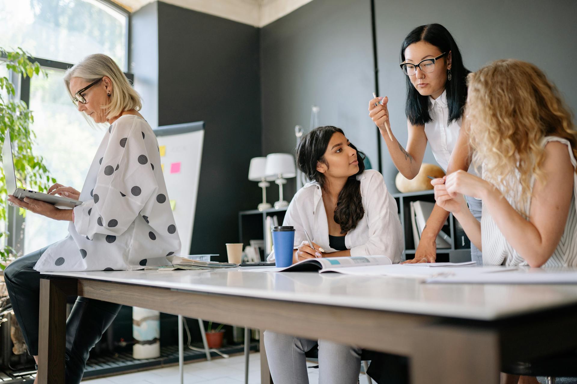 four women in an interior design practice discussing design work.