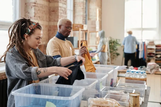 a black man and white woman shopping in a thrift store looking in bins